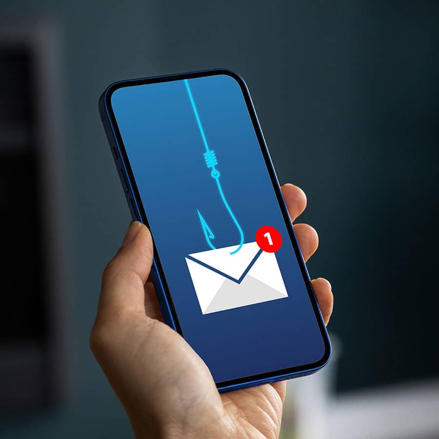 A hand holding a mobile phone showing a phishing icon
