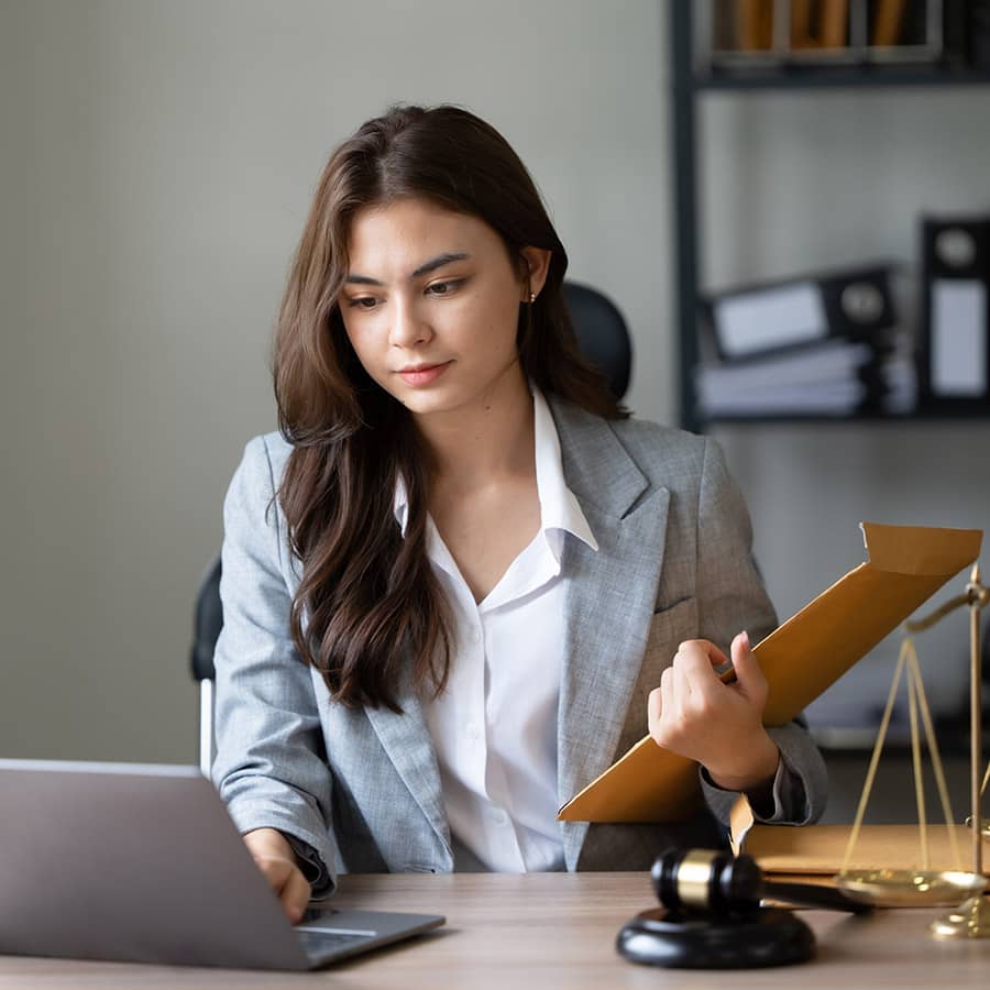 A lawyer works on a laptop at her desk