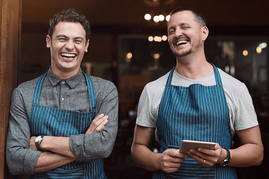 Two waiters standing together and laughing