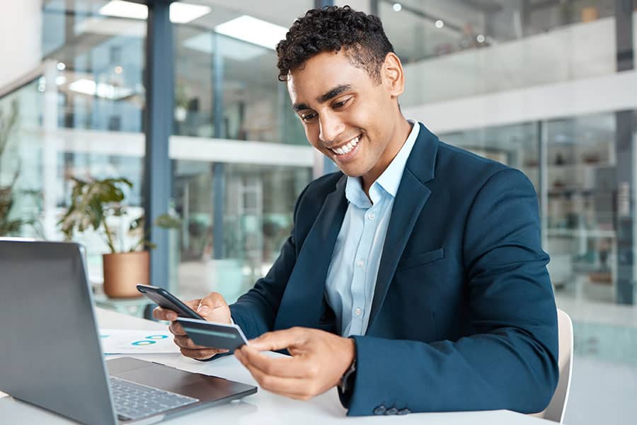 A man at his desk looks at his Sunstate Bank business debit card