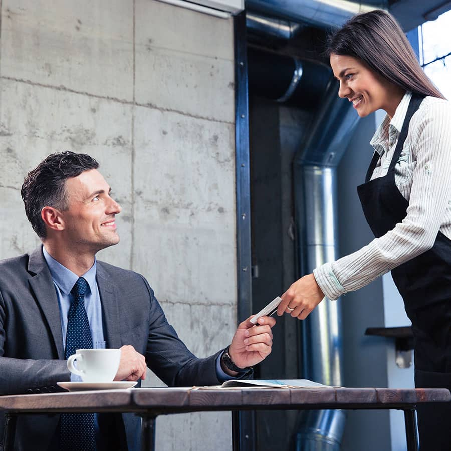 A business man pays for a meal with his Sunstate Bank Business Debit Card