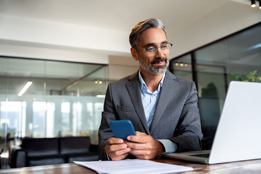 A man at his desk looking at his laptop screen