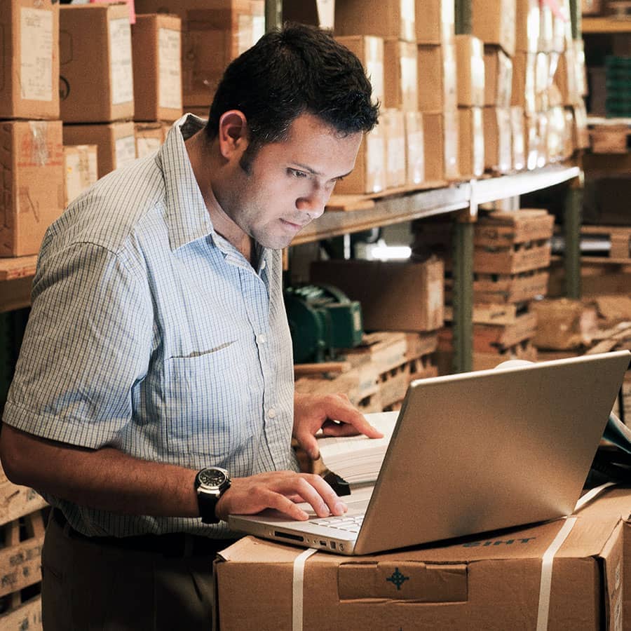 A man working on his laptop in a warehouse