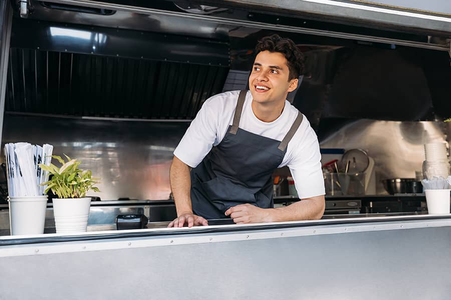 A man leaning out the window of his food truck