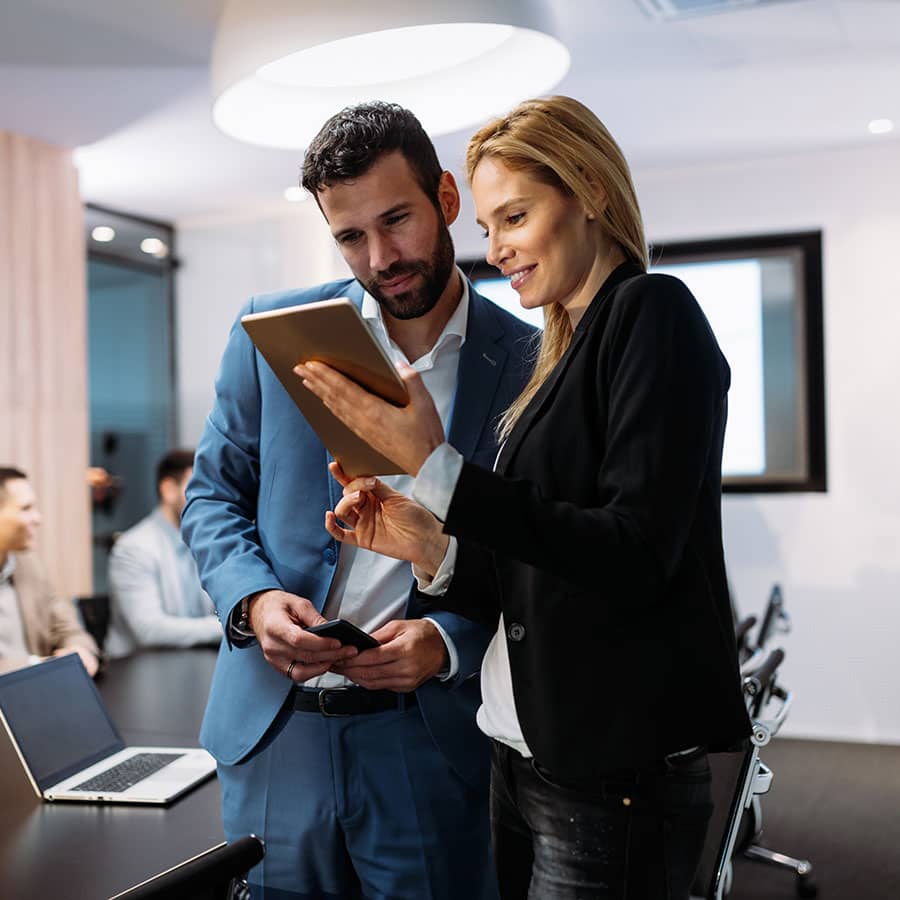 business people in a board room looking at a tablet