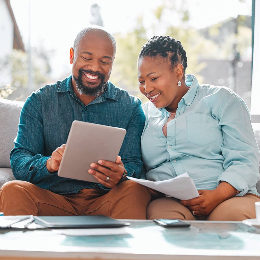 A middle aged couple looking at a tablet screen