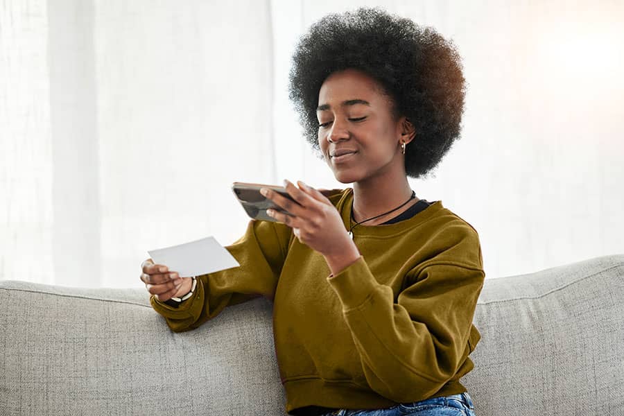 A woman taking a photo of the front of a check with her phone