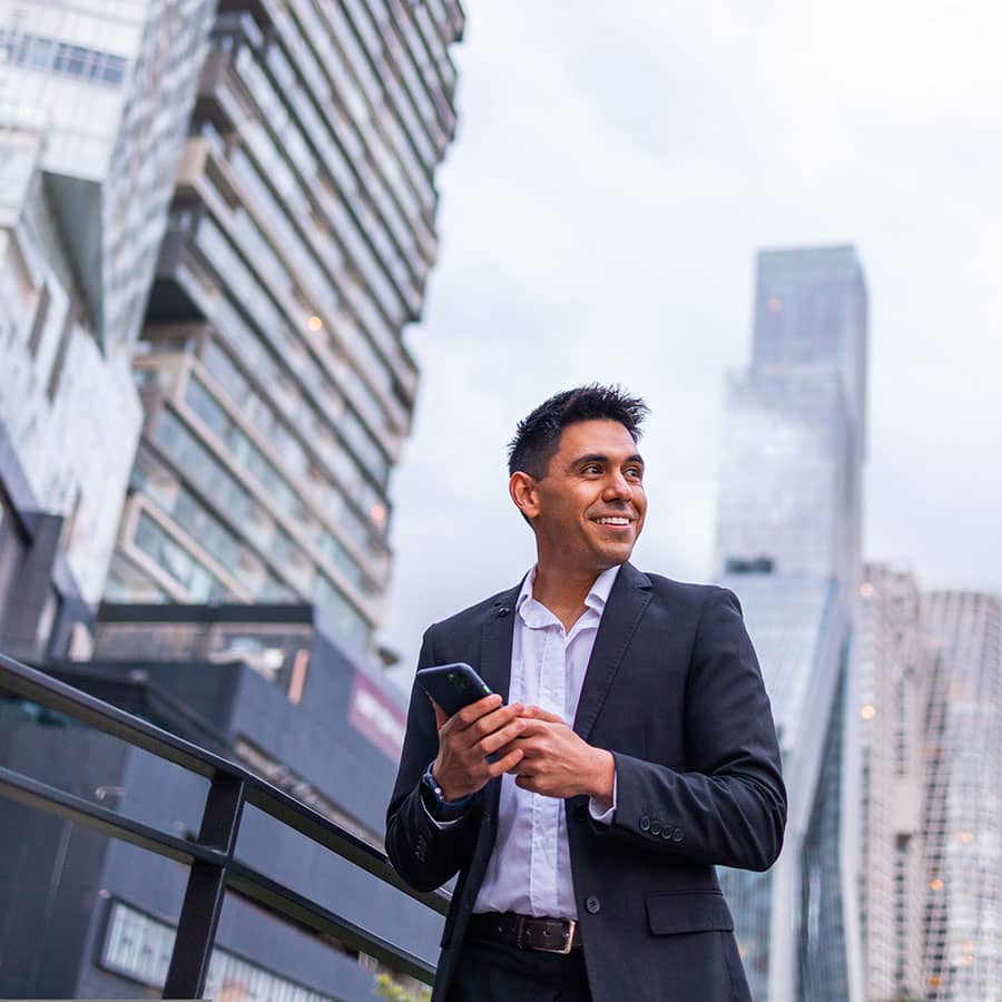 A man in the city holds a mobile phone