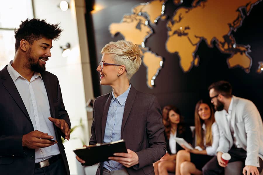 Business people working in front of a large global map