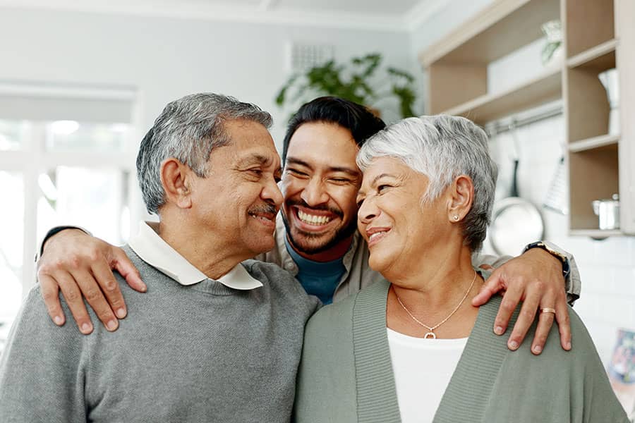 Grandparents hugging their grandson