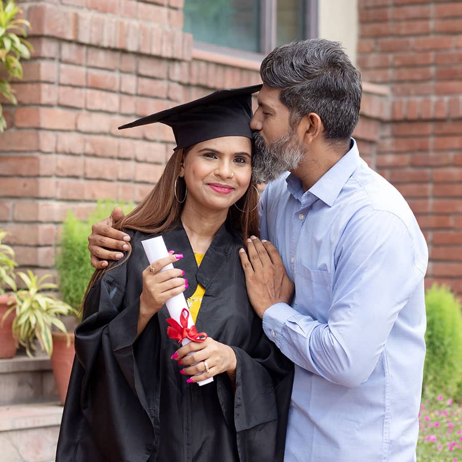 A parent kisses the forehead of a graduating student
