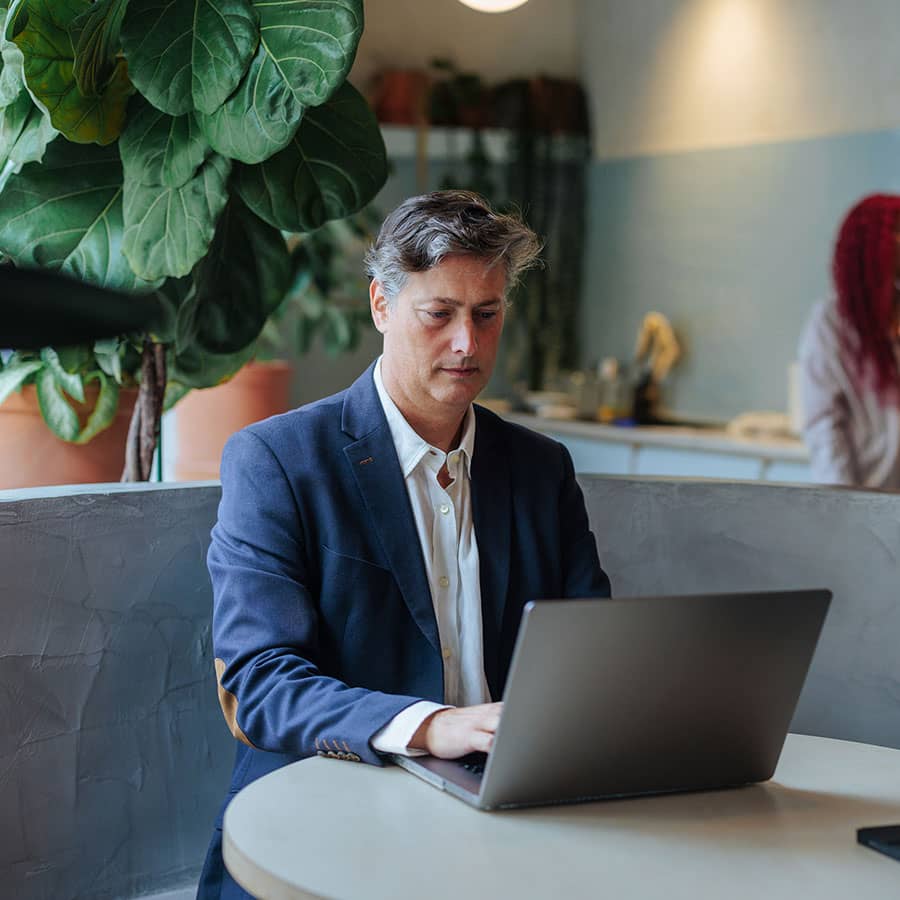 A business man in a cafe using his laptop