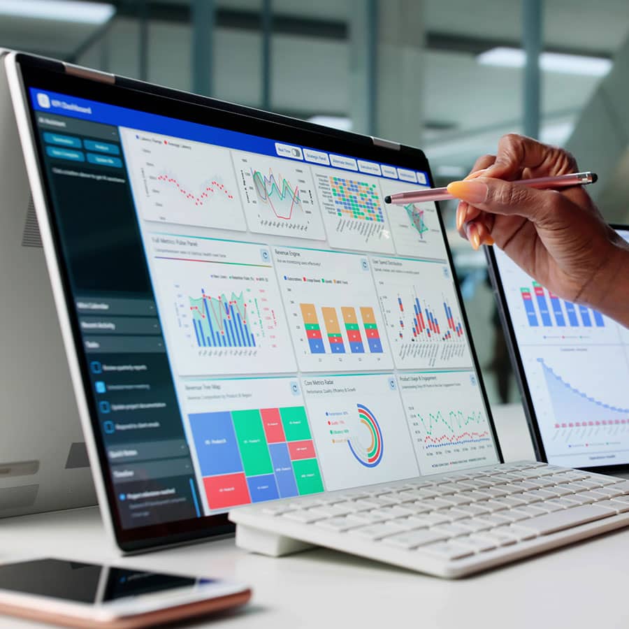 A laptop screen shows graphs and charts