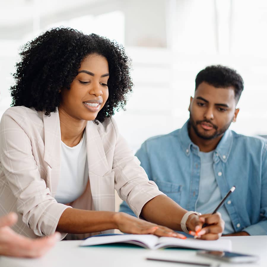 A woman working on paperwork with a man