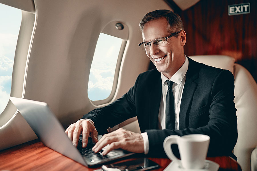 A man in a business jet on his laptop