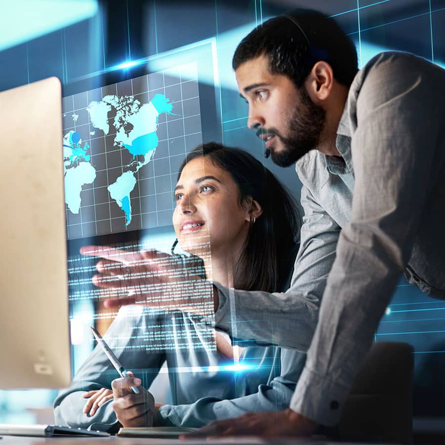 Workers look at a computer screen displaying a world map