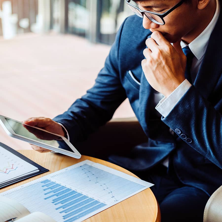 A businessman studying his phone and documents